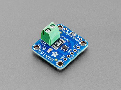 Angled shot of blue, square-shaped breakout board with a green terminal block.