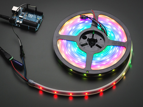 Adafruit NeoPixel Digital RGB LED Strip reel wired to a microcontroller, with all the LEDs in a rainbow