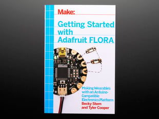 Front cover of Make: Getting Started with Adafruit FLORA. Making wearables with an Arduino-compatible electronics platform. By Becky Stern and Tyler Cooper. Topdown shot of a round dev board wired to LED PCBs.