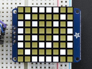 Close-up of soldered and assembled Small 1.2" 8x8 Ultra Bright Square White LED Matrix + Backpack on a breadboard powered by an Arduino Uno. The LED Matrix displays a white smiley.