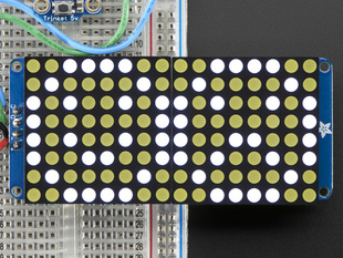 Close-up of Soldered and assembled 16x8 1.2" LED Matrix + Backpack - Ultra Bright Round White LEDs on a breadboard. The LED Matrices display a smiling emoji and a frowning emoji.