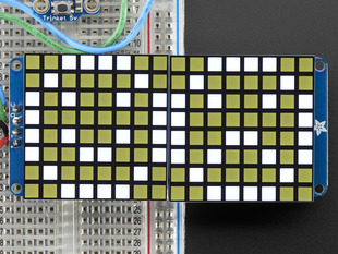 Close-up of Soldered and assembled 16x8 1.2" LED Matrix + Backpack - Ultra Bright Square White LEDs on a breadboard. The LED Matrices display a smiling emoji and a frowning emoji.