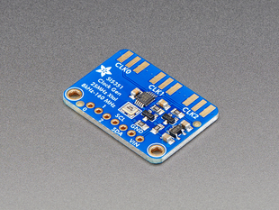 Angled shot of blue, rectangular clock generator breakout board.