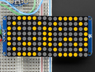 Close-up of Soldered and assembled 16x8 1.2" LED Matrix + Backpack - Ultra Bright Square Orange LEDs on a breadboard. The LED Matrices display a smiling emoji and a frowning emoji.