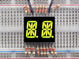 Yellow-green Dual Alphanumeric Display module wired to breadboard, all segments lit