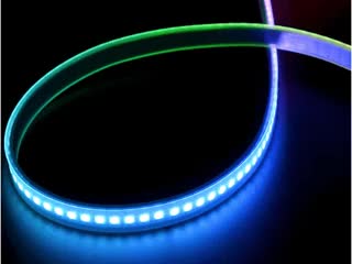 Shot of lightly coiled LED strip glowing rainbow colors.