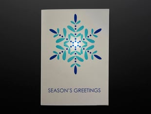 Front of Seasons Greetings card with snowflake design, and lit LED.