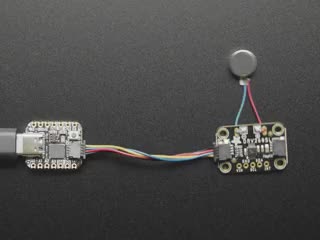 Video of a haptic controller breakout board with a vibrating motor disc soldered to it. The disc vibrates against the surface.