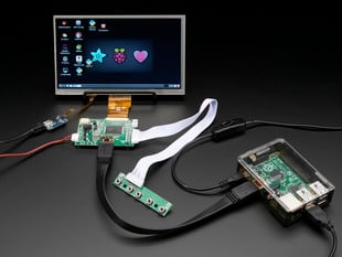 Front shot of a HDMI 4 Pi: 7" Display connected to a Raspberry Pi. The monitor displays a desktop background with a adafruit logo, raspberry logo, and a heart. 