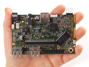 Hand holding Chumby Hacker Board a complex circuit board.