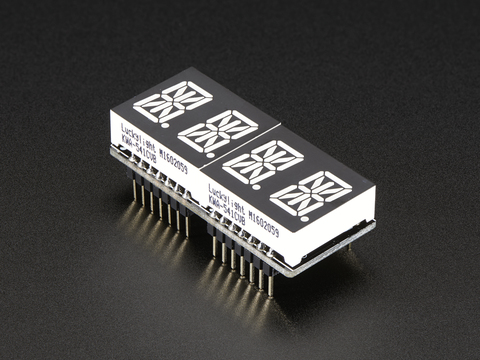 Angled shot of a rectangular shaped Quad Alphanumeric Display breakout board with an LED matrix soldered on.