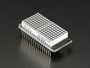 Angled shot of a rectangular shaped LED Matrix FeatherWing Display Kit breakout board with an LED matrix soldered on.