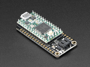 Angled shot of a black rectangular microcontroller adapter board assembled with an even smaller green microcontroller board.