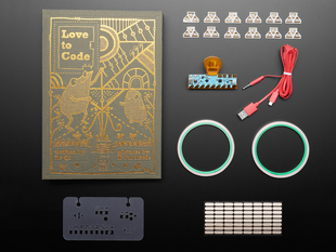 Top view of Love to Code Kit contents, including guidebook, Chibi Chip with plastic orange clip, red USB cable assembly, two rolls of copper tape, ten LED stickers.