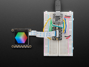 Overhead shot of 1.3" TFT breakout connected via EYESPI board and microcontroller on a half-size breadboard. The TFT breakout displays a colorful hexagon.