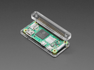 Angled shot of a green rectangular microcontroller, a Raspberry Pi Zero, assembled into a plastic and acrylic header installation jig.