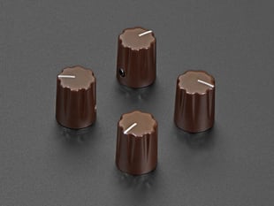 Angled shot of four brown plastic micro knobs.