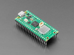 Angled shot of green rectangular microcontroller with a Wi-Fi module and pre-soldered headers.