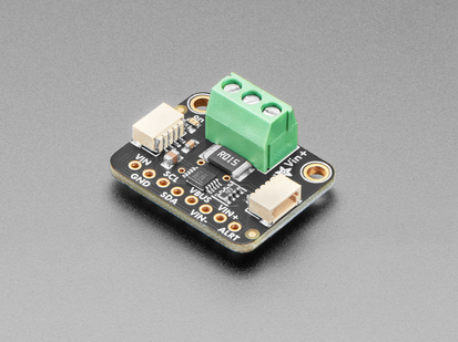 Angled shot of DC current monitor breakout board with green terminal block.