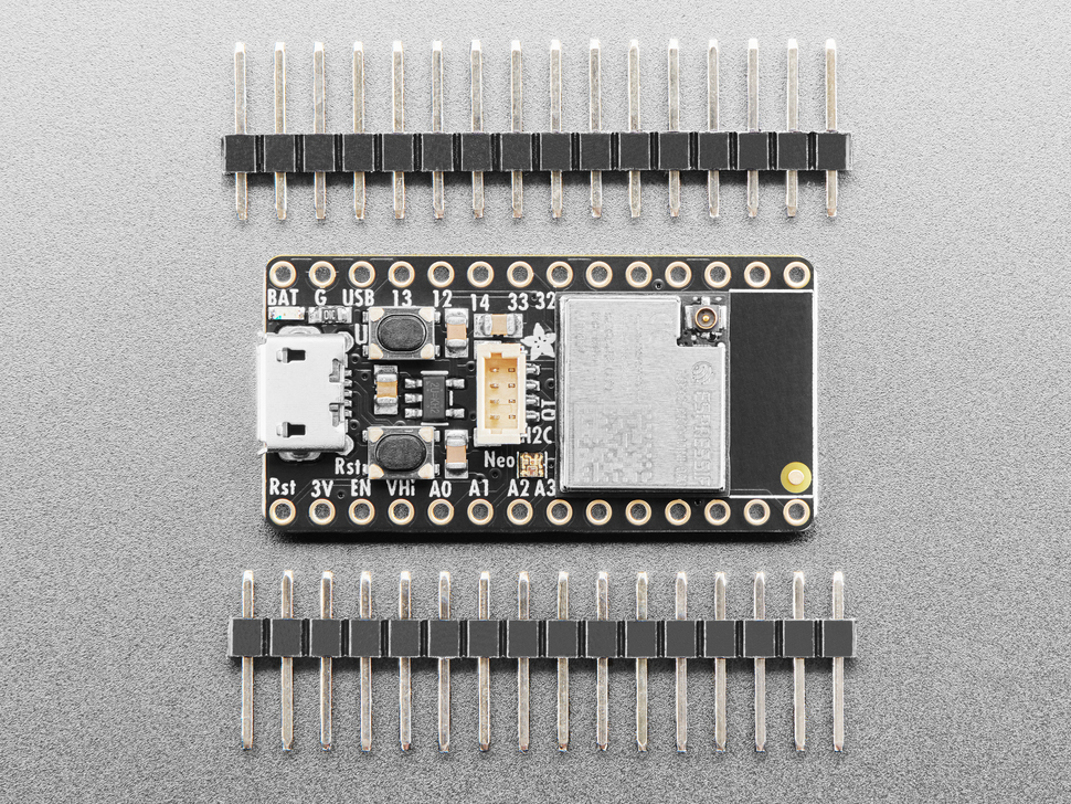 Overhead shot of black, rectangular microcontroller between two pieces of 16-pin header.