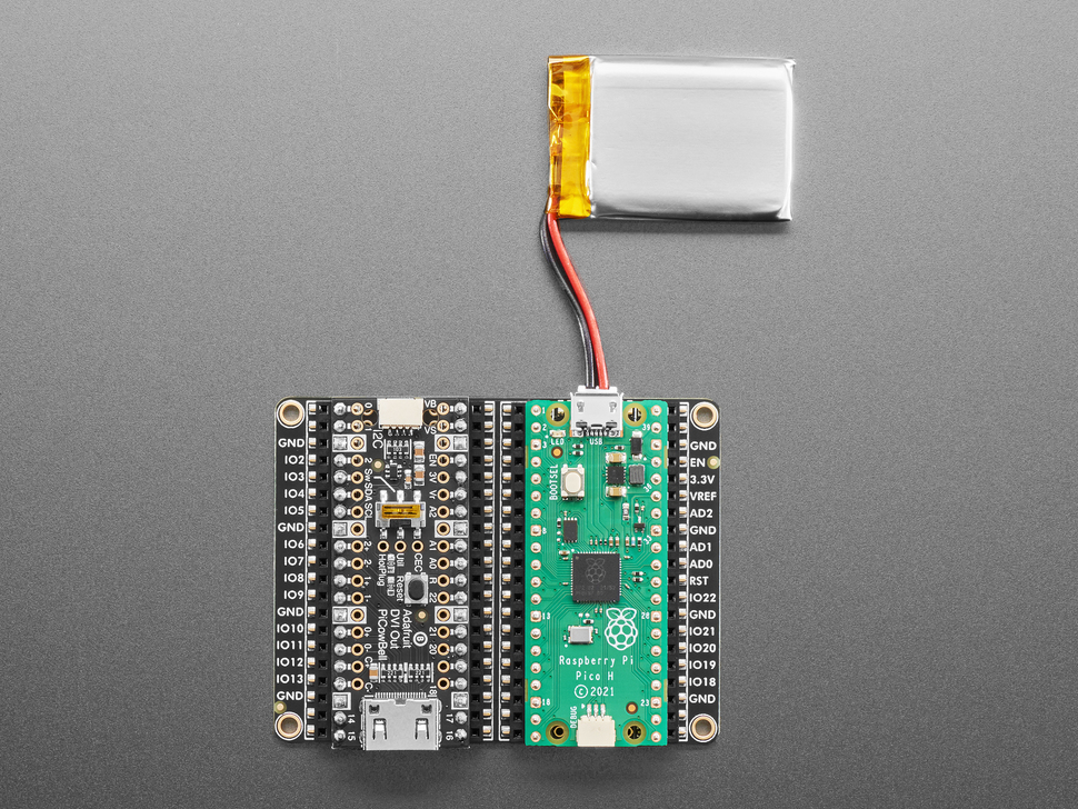 Overhead shot of black, rectangular prototyping board with a lipo battery and sensor.