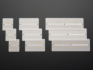 Top view of three packs of three different sized Adafruit Perma Proto-Board PCBs.