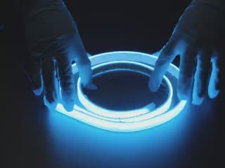 Video of gloved hands playing with a blue LED strip.