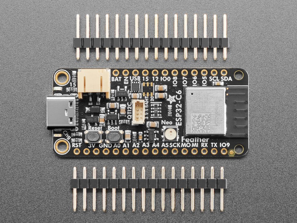 Overhead shot of rectangular dev board between two pieces of 16-pin header.