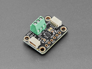 Angled shot of black, rectangular breakout board with a green 3-pin terminal block.