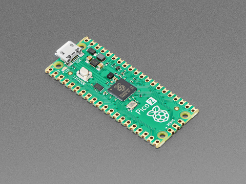 Angled shot of thin, green rectangular microcontroller with castellated pads.