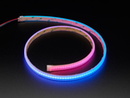 Angled shot of LED strip in a spiral, emitting pink and blue colors.