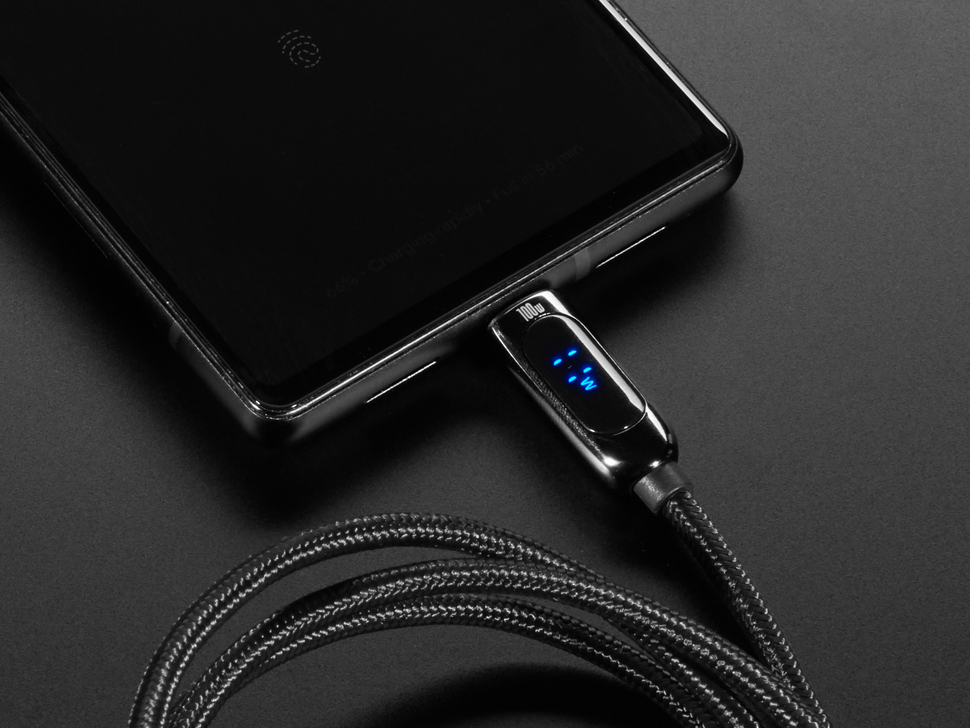 Lifestyle image of black woven fabric cable plugged into a smartphone. The digital display on the cable reads 11W.