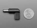 Overhead shot of barrel-jack-to-USB-C-socket right angle adapter next to US quarter for scale.