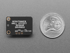 Back of black, rectangular hall sensor breakout board next to US quarter for scale.