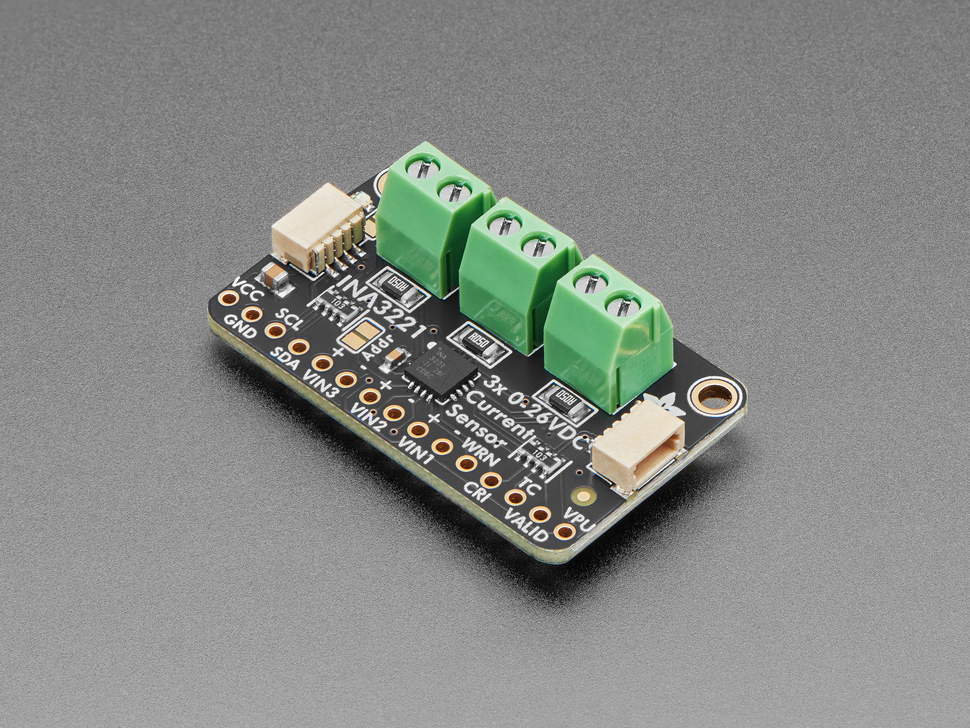 Angled shot of rectangular breakout board with three 2-pin terminal blocks.