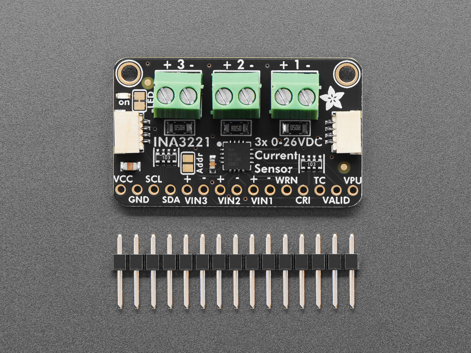 Overhead shot of rectangular breakout board with three 2-pin terminal blocks above a 16-pin header.