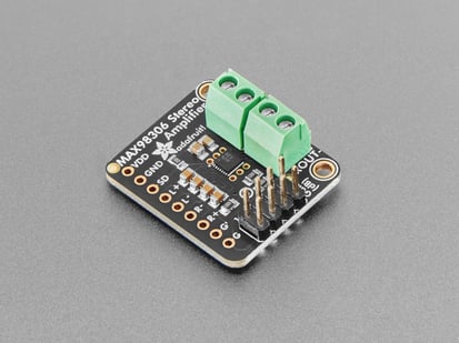 Angled shot of black, square-shaped audio amplifier board with pre-soldered terminal blocks and 2x4 header.